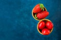 Ripe organic strawberries glossy sweet cherries in waffle ice cream cones, dark blue background, template