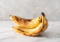 Ripe overripe organic bananas on concrete background. ugly food zero waste concept