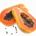 Ripe papaya fruit with seeds split into two parts on a white background