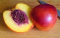 Ripe peach with a bone on a cutting board. Cut with a knife.