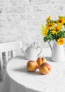 Ripe peaches and a bouquet of yellow flowers on the table on a light background. Cozy home kitchen still life Royalty Free Stock Photo