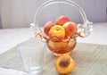 Ripe peaches and glass of juice on a table, cut peach, of a beautiful vase in the shape of a basket background.