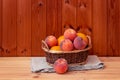 Ripe peaches and oranges in basket on wooden table Royalty Free Stock Photo