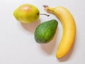 Ripe pear, avocado and banana on the white marble table.