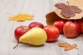 Ripe pear and red apples with paper bag on wooden desk Royalty Free Stock Photo