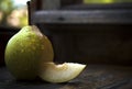 Ripe pear on a wooden table with water drops