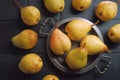 Ripe pears on an old tray, on a black slate stone.