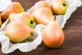 Ripe pears in a paper on a wooden table Royalty Free Stock Photo