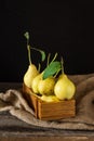 Ripe pears in a wooden box on the table. Fresh ripe organic pears on rustic wooden table, natural background, vega, diet food.