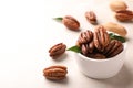 Ripe pecan nuts in dish served on light table