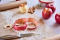 Ripe peeled apple, knife, cinnamon, flour, parchment paper on the table. Preparation for cooking pastry Royalty Free Stock Photo