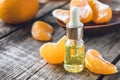 Ripe peeled slices of tangerine without peel and a bottle of essential oil with tangerine on the table Royalty Free Stock Photo