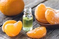 Ripe peeled slices of tangerine without peel and a bottle of essential oil with tangerine on the table Royalty Free Stock Photo