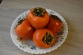 Ripe persimmon fruit on a Cup on the table.