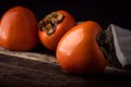 Ripe Persimmon fruit on old wooden table, close-up