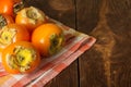 Ripe persimmon fruits lie on a towel on dark