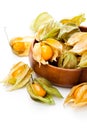 Ripe physalis in wooden bowl on white background Royalty Free Stock Photo