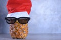 Ripe pineapple, ananas with glasess in Santa`s hat. New Year fruit concept