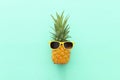 Ripe pineapple in stylish sunglasses over wooden blue background. Tropical summer vacation concept. top vew