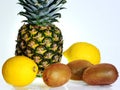 A ripe pineapple with two lemons and three kiwi fruits on white background Royalty Free Stock Photo