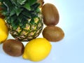 A ripe pineapple with two lemons and three kiwi fruits on white background Royalty Free Stock Photo