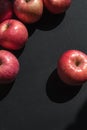 Ripe pink apples on a black surface, top view