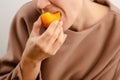 Ripe pleasure: An alluring woman indulges in a ripe yellow plum, finding pleasure in the ripe juiciness of her fruity