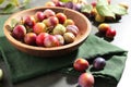 Ripe plums in bowl on grey table, closeup Royalty Free Stock Photo