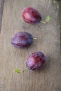 Ripe Plums On Old Wood Table