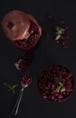 Ripe pomegranate, bowl spoon with pomegranate seeds on a black background. Top view