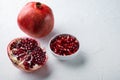 Ripe pomegranate with fresh juicy seeds, on white textured background with space for text