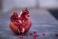 Ripe pomegranate fruit on a dark concrete background