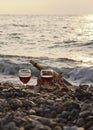 Ripe pomegranate fruit with a glass of wine and a bottle on the beach. Romantic day at the seaside Royalty Free Stock Photo