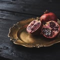 Ripe pomegranate fruit on black wooden vintage background