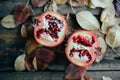 Ripe pomegranate fruit on wooden vintage background. Red juice p Royalty Free Stock Photo