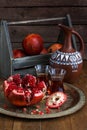 Ripe pomegranate fruit on wooden vintage background. Red juice pomegranate on dark background. Fresh juicy pomegranate - Royalty Free Stock Photo