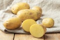 Ripe potato tuber cut in half on coarse burlap fabric.