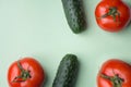 Ripe raw organic tomatoes cucumbers on light lettuce green background. Balanced diet vegan superfoods healthy lifestyle vitamins