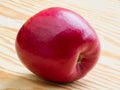 Ripe red apple lying on a wooden table top Royalty Free Stock Photo