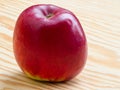 Ripe red apple lying on a wooden table top Royalty Free Stock Photo