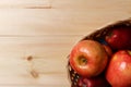 Ripe red apples in a basket on a bright wooden background