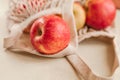 Ripe red apples in a light string bag on a beige background close-up Royalty Free Stock Photo