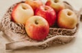 Ripe red apples in a light string bag on a beige background close-up Royalty Free Stock Photo