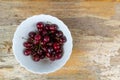 Ripe red cherry berries in a white bowl autumn harvest on a wooden background table copy space Royalty Free Stock Photo