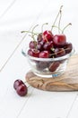 Ripe red cherry close-up in a glass bowl on a wooden stand. Royalty Free Stock Photo