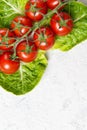 Ripe red cherry tomatoes on Romain Lettuce leaves, stone table, top view with copy space Royalty Free Stock Photo