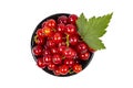 Ripe red currant berries in a black ceramic cup with natural green leaf on white, isolated, top view Royalty Free Stock Photo