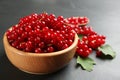 Ripe red currants in wooden bowl on black table Royalty Free Stock Photo
