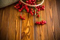 Ripe red dogrose in a basket on a wooden