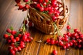 Ripe red dogrose in a basket on a wooden